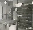 Brevbärarexpeditionen i Sundsvalls postkontor, försortering av korsband. Brevbärarförman E. Höglund.