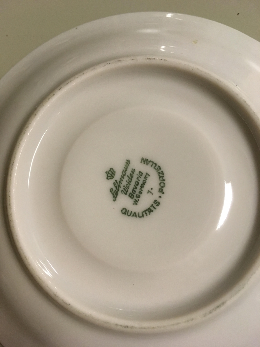 To asjetter, ett tefat og en kopp i hvitt porselen med grønn kant fra Porsgunds Fjellflora-serie. Blomsterdekor i grønt, gult og lilla.

To asjetter, ett tefat og to kopper i hvitt porselen med gullkant fra Bavaria-Germany. Motivet ligner Porsgrunds motiv, men ikke ren kopi.