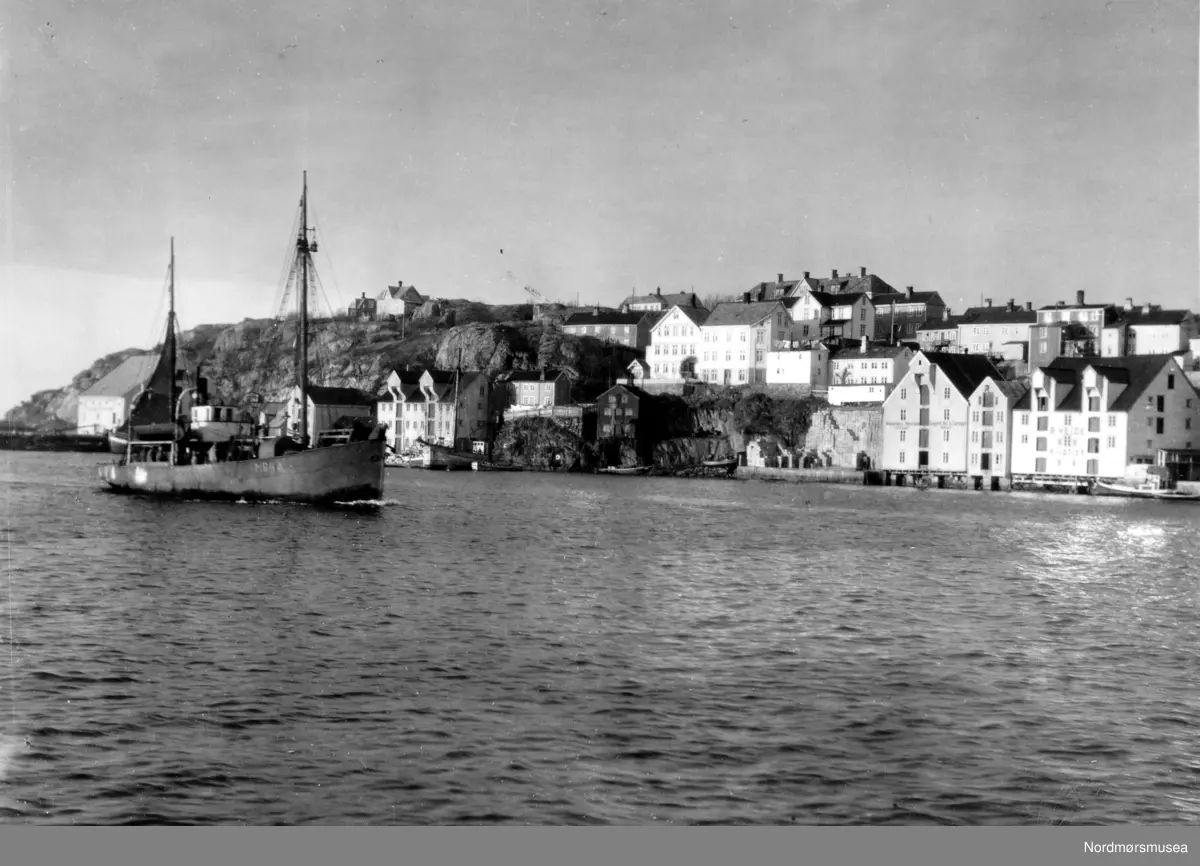 Bildet er fra havna i Kristiansund og viser M/S”Bjørnøy” M-84-A i fart inn Sørsundet.
Stålbåtens hoveddimensjoner er: L = 62 fot x B= 12,4 fot x D= 8 fot og byggeår er 1987 og utrustet med en BERGEN dieselmotor på 3300 hk, byggeår 1987. 
Eiere er Bernt Skarbøvik  A/S, Ålesund. I bakgrunnen ses Kirklandet med Jemar Norpowerbrygga bak fiskebåten. Info: Peter Storvik. - 
Båt i Sørsundet på vei inn til Kristiansund.
I bakgrunnen ser vi bryggene i Håla og Sørholmen på Kirkelandet.  Oppe til venstre ser vi noe av bebyggelsen  på Hålahaugen og sykehuset i Frueenget som var ferdig i 1899. 
I bakgrunnen ses Kirklandet med Jemar Norpowerbrygga bak fiskebåten
Nordmøre museums fotosamling