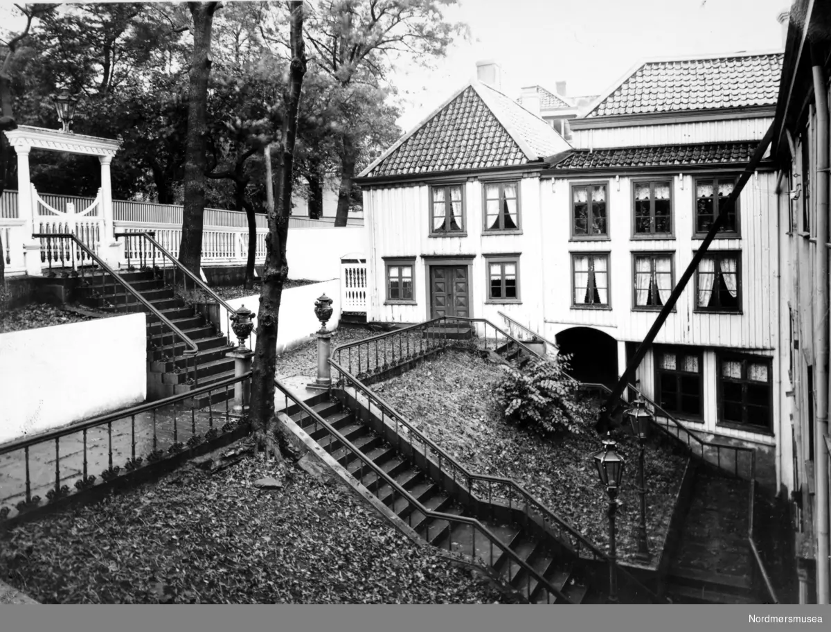 Foto fra Knudtzongården som lå i Storgata på Kirkelandet i Kristiansund. Her ser vi trappen som leder ned til bygningen. Fotograf er Anders Beer Wilse, og datering er trolig omkring 1902 til 1930. Fra Nordmøre Museums fotosamlinger.