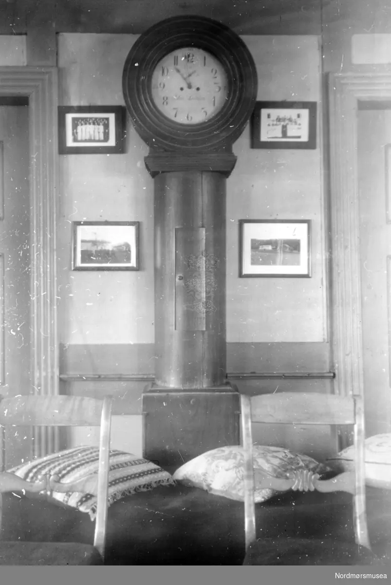 På bildet ser vi et gammelt empire klokkeskap av furu. Midt på tallskiven står navnet John(?) Dahlen. Etter eierens utsagn (Lars Bastiansen Søyset) skal J. D. være en klokkemaker fra Meldal i Sør-Trøndelag. Nordmøre Museum