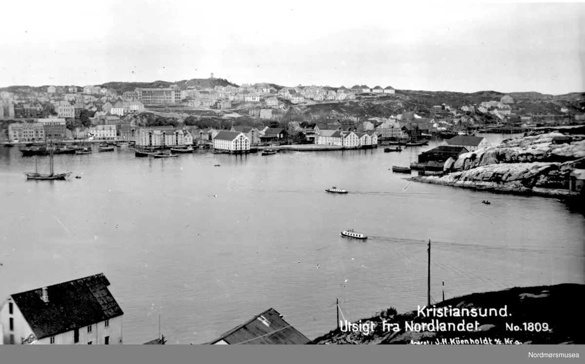 Peter Storvik: Bildet viser Dahlesundbåten M/S »Dahle» til A/S J. Storviks Mek. Verksted på Dahle ved Kristiansund i full fart på havna i Kristiansund på vei til byen. Bortenfor ses sundbåtselskapets sundbåt som traffikerte på havna.
De fleste forbinder sundbåtene i Kristiansund med dagens rute som går mellom Kirkelandet, Innlandet, Nordlandet og Gomalandet. Den blir betegnet som en av verdens eldste båtruter. Mindre kjent er ruten som en tid gikk fra Dahle til byen.
Fra 1910-1912 ble verkstedets egenbygde sundbåt D/S «Oma» bygg nr.3 brukt til personelltransport til og fra byen.
Fra 1912-1920 overtok Christiansund Dampbaadsamlag (byens sundbåtselskap) transporten mellom Dahle og byen med sundbåten D/S «Lyn», med økonomisk støtte fra verkstedet og gratis  vannleveranse til kjelen. I 1920 ble sundbåtselskapets rute til Dahle nedlagt.
Fra 1920 - ca.1922 leide verkstedet en personelltransportbåt D/S «Klar» av en kristiansunder for å opprettholde Dahleruten.
På 20-tallet bygde A/S J. Storviks Mekaniske Verksted en sundbåt på et brukt stålskrog som de hadde og som var nedrigget tidligere og brukt som slepelekter.
Den ble satt i drift ca.1922 og frem til ca. 1936.
Båtskroget hadde gått som slepelekter etter M/B «Kalven» i flere år. Der hadde det blitt brukt til frakting av jern og annet tungt gods fra byen. 
Den ble senere bygd om til sundbåt. Nytt styrehus, overbygget tak og flotte eiketrebenker og en ensylindret motor gjorde dette til et godt bindeledd mellom Dahle og Kristiansund og fikk navnet 
M/S «Dahle». 
Grunnen til at A/S J. Storviks mek. Verksted engasjerte seg i dette var hovedsakelig å frakte arbeidsfolk fra byen til verkstedet. 
Den ble etter hvert så populær at den også ble viktig for andre enn arbeidere ved verkstedet. Båten var en god sjøbåt og trosset dårlig vær og ble til å stole på når det gjaldt å komme frem. Derfor gikk den flere turer utenfor selve arbeidsrutene på morgen og kveld. Første fører var Johannes Nålsund deretter Samuel Larsen som førte båten storparten av tiden. 
Sundbåten ble også et naturlig valg når det gjaldt å få fraktet varer fra byen til Dahle. Varene ble så hentet med hest og kjerre ved sundbåtkaia som lå på den vestre delen av verkstedområdet rett nedenfor Ole Storviks bolighus. 
Slik det ofte blir der hvor folk ferdes, ble også sundbåtkaia på Dahle et populært møtested for folk. Her kunne ungdommene på Dahle møtes, og det skjedde også at de tok seg en dans nede på kaia hvis noen dro fram et munnspill. Vi kan nok anta at det ble litt flørting også i lune sommerkvelder. 
På denne tida var Dahle som kjent en del av Bremsnes kommune. Dette gjorde at sundbåten også tok turer helt ute til Bremsnes. Særlig var dette aktuelt i begravelser eller andre spesielle anledninger. Familien Storvik hadde blant annet sitt familiegravsted ved Bremsnes kirke. 
Det går flere historier om sundbåtens ferd i all slags vær. Det er ikke vanskelig å tenke seg at det nok kunne bli ganske heftig når tåka la seg, eller snøkaven satte inn. 
På slutten av 20-tallet ble det trangere tider. Verkstedet møtte motgang, og sundbåten ble tatt ut av rute. I mange år ble den lagt i en bøye, og rustet sakte, men sikkert. En stormnatt sank den utenfor skjærrekka på Høttnesset og ble liggende. Da krigen brøt ut ble den hevet av tyskerne og jernet i den ble brukt på ny.


-- Foto fra havnebassenget i Kristiansund, hvor vi ser fra Nordlandet helt i front, en flikk av Gomalandet på høyre side, samt kirkelandet som strekker seg over hele bildet i bakgrunnen. Legg forøvrig merke til seilskutene i Johnsenhuken på Kirkelandet side, samt sundbåtene mellom Gomalandet og Nordlandet.
 Den nærmeste sundbåten er antakelig arbeidsbåten fra Storvik mek. verksted på Dale.
 Informant Peter Storvik:
 Dette var den siste sundbåt/verkstedbåt som verkstedet hadde malt J. Storviks mek. verksted på siden og er også avfotografert ved piren på Kirkelandet.
 Den var i drift fra 1922 - 1936 da Nordsundbrua var bygd.
 Utgiver er J. H. Kühenholdt a/s. No 1809. Fra Nordmøre museums fotosamlinger.