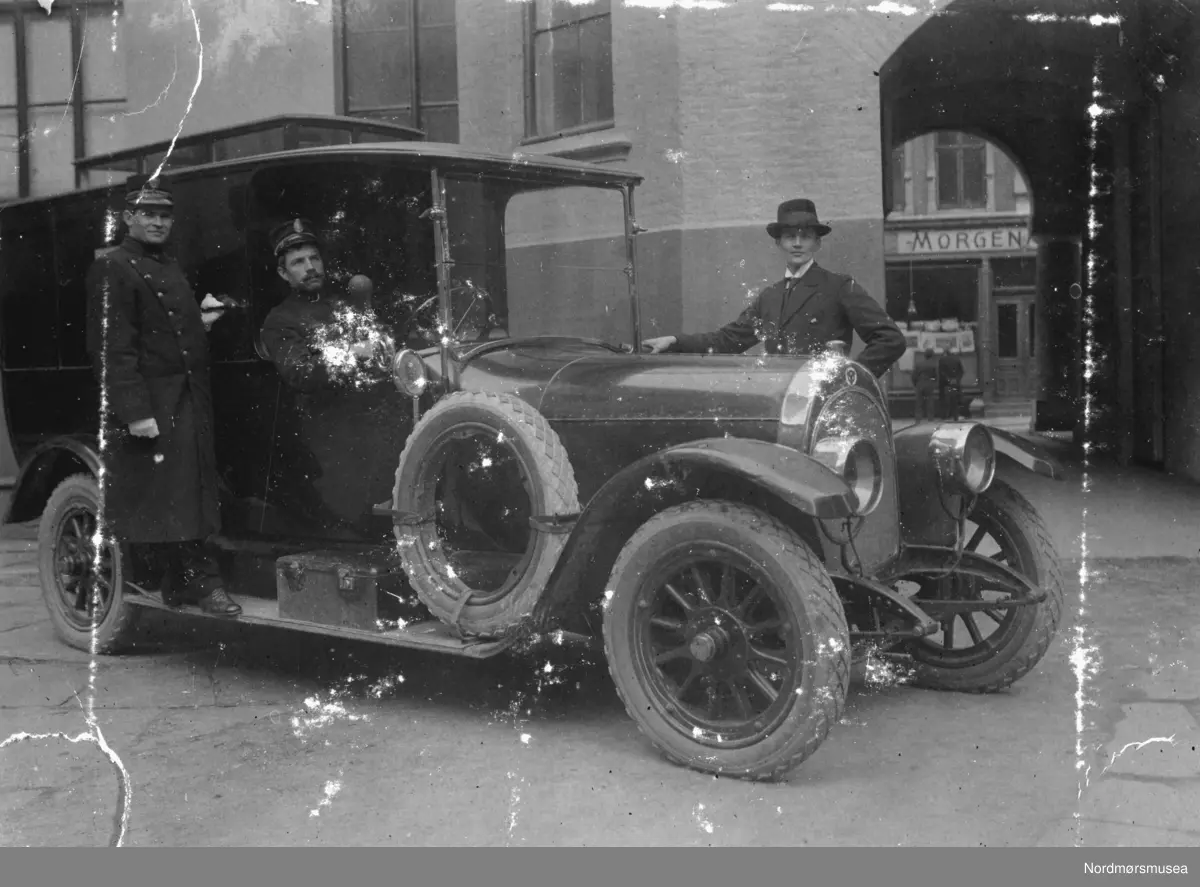 En Scania Vabis ca 1916-modell utenfor politikammeret i Bergen, Allehelgens gate 3. Morgenavisens lokaler i bakgrunnen, Allehelgens gate 6.  Jeg finner ikke spor etter noen politibil i Bergen av dette merket. Derimot hadde de en sykebil.  Men denne er vel for "uniformert" til å være sykebil med personale? Info: Trygve Krogsæter m.fl. - Bilen er en Scania Vabis tilhørende Bergen Politikammer.(Jørgen Rønning). 


Vi ser vi tre menn ved bilen. Den første i førersetet og en stående på bilens trappetrinn. Begge i politiuniform. Tredjemann står bak bilen, og er i sivil. Dette albumet har tilhørt Marit Hestvik, og viser bilder fra familien Rødsand/Hestviks fotoalbum fra Kristiansund. Det ble gitt til Nordmøre museum av Nelly Rødsand 5. september 1983. Fotoalbumet består av bilder med reg. nr. KMb-1983-024.0049 til KMb-1983-024.0223. Flere bilder fra andre album er å finne på samlingsnummer KMb-1983-024. Fra Nordmøre museums fotosamlinger.