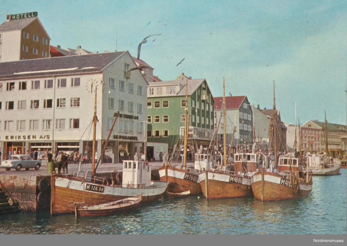 Båter på kaia:


Mk «Lindøy»	M-126-BV
Trebåt bygd 1928. Ombygd 1951.
50x13x6,3 fot. Hjelseth 42 hk fra 1946.
Eier: Johs P Lind, Vestsmøla. --

Mk «Buafjell»	M-76-BU 
Trebåt bygd 1915. Ombygd 1948.
53x15,5x7,5 fot. 31 brt. 10 nrt.
Heim 55 hk fra 1942. 
Eier: Harald Tungehaug m.fl., Bud. ---

Mk «Heim 2»	M-48-BU 
Trebåt bygd 1919. Ombygd 1934.
57x16,5x7,5 fot. 35 brt. 8 nrt.
Finnø 100 hk fra 1942.
Eier: Oddmund Fjøren m.fl., Bud. ---

Mk «Barsund»	M-41-BU
Trebåt bygd 1916. Ombygd 1937.
Bolinder 60 hk fra 1942.
Eier: Asbjørn Kristengård m.fl., Bud. --

kilde: Register over Merkepliktige Norske Fiskefarkoster (info via
Nils-Rune Torrissen) -

Postkort "821/25" med Rådhusplassen på Kirkelandet i Kristiansund, sett fra Piren. Til venstre ser vi blant annet Jonas Eriksens skipshandel. Jonas Eriksen har vært å finne nær sagt på samme plass, helt siden 1902 til 2016. Like ovenfor Jonas Eriksen ser vi Bondeheimen, senere Fosna Hotell. Hotellet stod ferdig trolig rundt 1954-1955. Ellers så ser vi flere båter liggende langs kaien, hvor vi blant annet ser flere fiskebåter nær fisketrappa. Disse har registreringsskiltene "M-126-BV", "M-76-BU", M-48-BU" og "M-41-BU".   Kortet er utgitt av Mittet & Co. A/S.  -- Dette bildet må være tatt før 1963. Da ble nummerene på båtene forandret fra BU til F. Det ble gjort i forbindelse med komunesammenslåingen av BUD, Hustad og Fræna til Fræna komune. Forøvrig så er det min far`s båt "Buafjell" M-76-BU som ligger nærmest kaia. Info fra Pål H Tungehaug 2018). Fra Nordmøre Museums fotosamlinger.