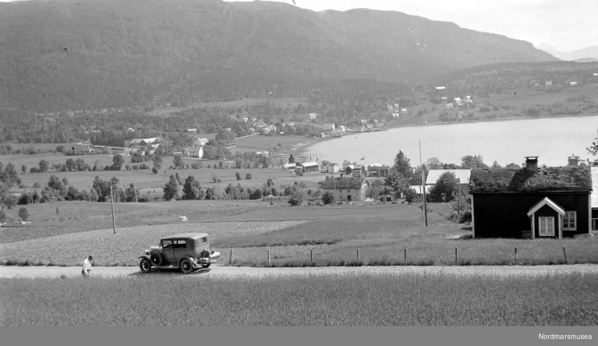 Tingvollvågen. Utsikt frå nord over inste vågen med fergekaia. Koksviklia opp mot Kjerkjeberget i bakgrunnen.  (Info: Lars Brubæk). Fra Nordmøre museums fotosamlinger.