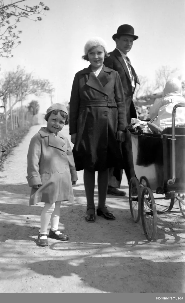 Portrett av en mann med bowlerhatt og frakk, en ung kvinne, pike og et spedbarn i barnevogn. Vedkommende er trolig fra Sverdrupfamilien i Kristiansund.
Datering og sted er ikke kjent. Fra Nordmøre museums fotosamlinger.
