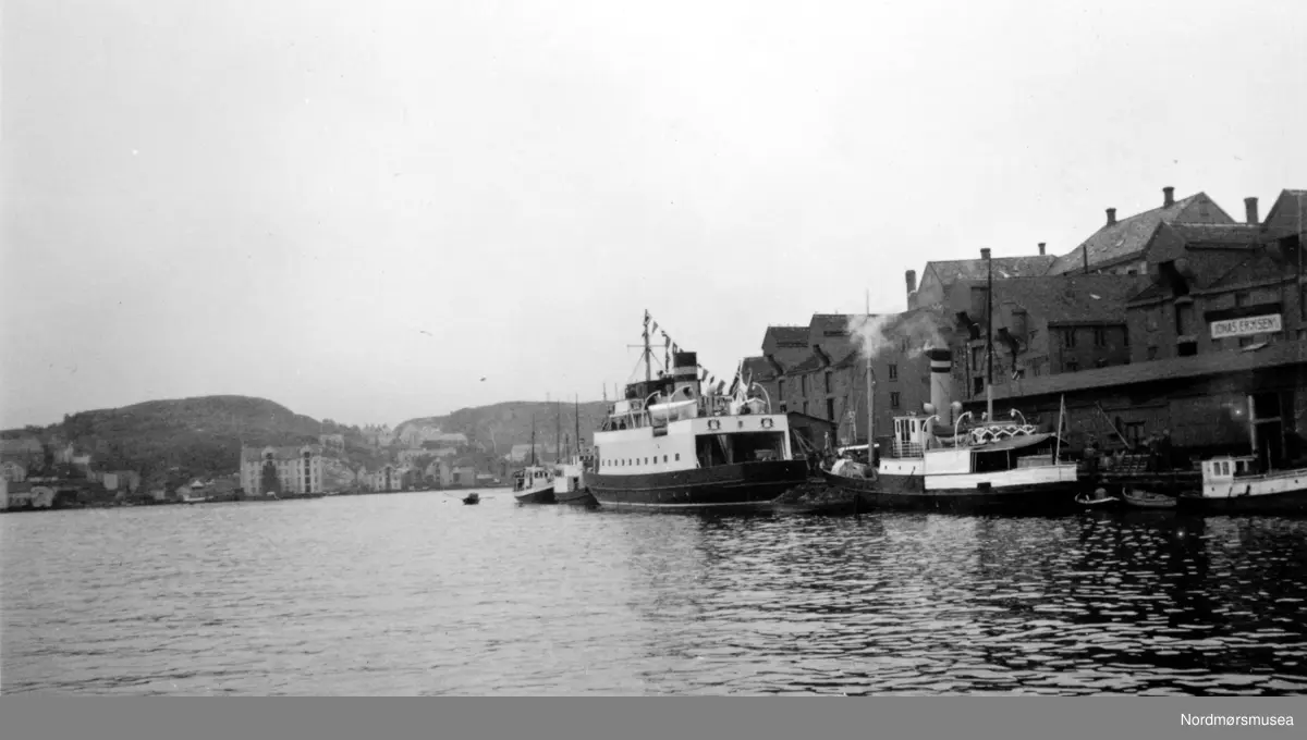 Bilferge og rutebåt ved Storkaia på Kirkelandet i Kristiansund. Bildet er tatt fra Piren mot Storkaia. Bildet viser bilferja "Geiranger" som ble bygget ved Trondhjems Mekaniske Verksted i 1937 og satt i trafikk mellom Geiranger og Hellesylt. Bildet er sikkert tatt på turen fra Trondheim og sørover.
(Info fra Magnar)   -- Dampskipet nærmest på bildet er D/S Ternen. Tidligere eid av Nordre Søndmøre Dampskipsselskab
(info: Arnfinn Herkedal). -- 



Bilferge og rutebåt ved Storkaia på Kirkelandet i Kristiansund. Bildet er tatt fra piren mot Sørsundet. Ferga ser ut til å være B/F”Geiranger” til Møre og Romsdals Fylkesbåter flaggsmykket ved kaia og bildet er sansynligvis fra 1937, da den ble levert fra Trondhjems mek. Verksted i Trondheim. Rutebåten foran ferga tilhørte også samme rederiet. Bak B/F”Geiranger” ligger det også noen båter blant annet en til fra samme rederiet. Til venstre ses Innlandet med bryggene. (Peter Storvik) Fra Nordmøre museums fotosamlinger.