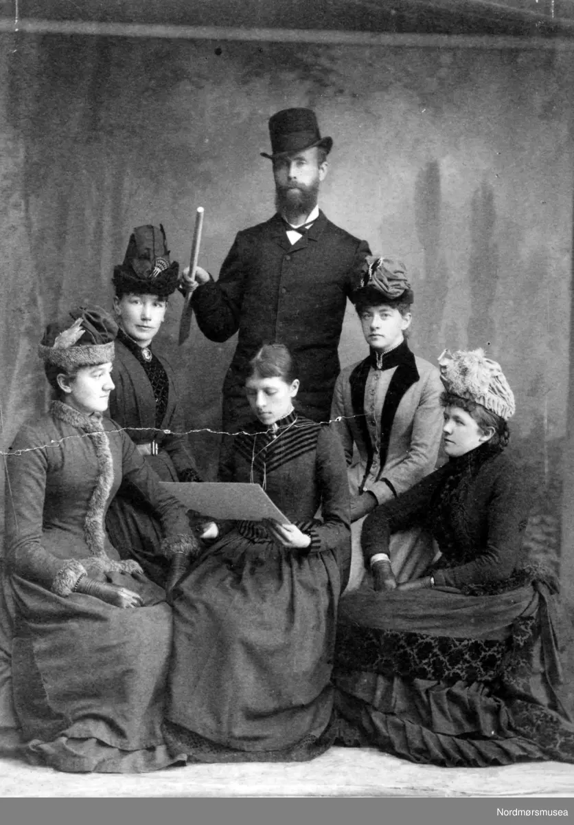 Cabinet-portrett bilde med teksten ";litt av Hans Oppigård Eikisdal"; bak på kortet. Usikker på om nevnte person er avbildet. Ellers ukjente personer. Fotograf er Johan K. Engvig, og bildet er trolig fra 1890 til 1910. Fra Nordmøre Museums fotosamlinger.
