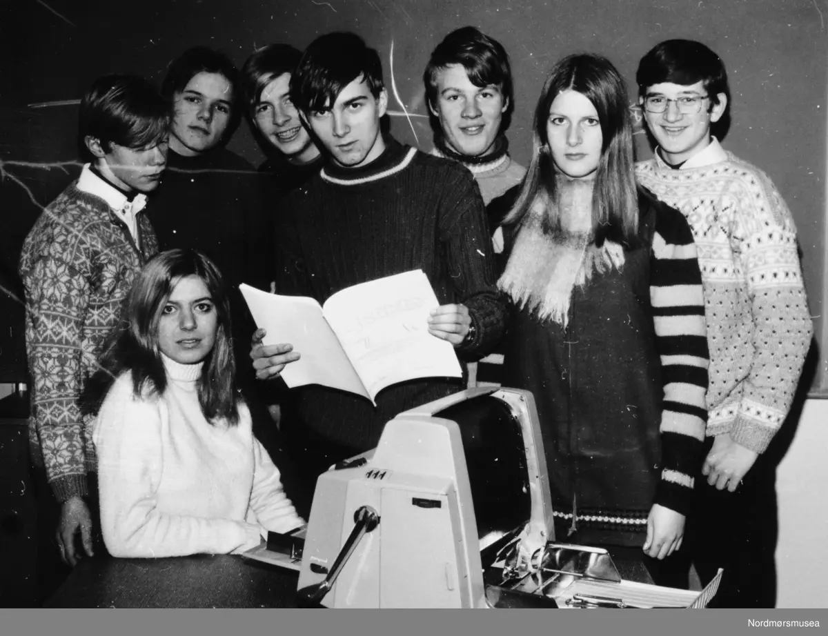 Foto fra Nordlandet ungdomsskole, Januar 1970: her fra skoleavisa Oraklet. Spritstensil. Redaktør var Stein Magne Bach. Her ser vi fra første rekke til venstre: Norild Alida Skomsøy, Stein Magne Bach og Anne Arntzen. Fra bakerste rekke fra venstre: Harald Bergseth, Kjell Strømsvåg, Kjell Ove Sæther, Kjell Herskedal og Arve Romuld. Fra Nordmøre museums fotosamlinger.

