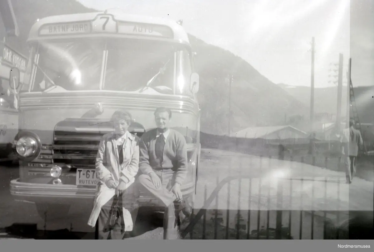 Bussen på bildet er T-6708 Volvo 1952-modell med karosseri fra Bussbygg. Dette var en turbuss med 34 sitteplasser og ble mye brukt på turer i inn- og utland på 1950-tallet. (Info: Sveinung Berild - 07.10.2016).  Foto av en mann og en kvinne foran en rutebuss fra Batnfjord auto. Det er ukjent hvem vi ser på bildet, samt hvor og når bildet er tatt. Muligens i Batnfjorden? Se forøvrig KMb-2008-024.N560 og KMb-2008-024.N563. Fra Nordmøre museums fotosamlinger.