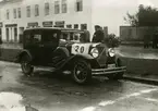 Biltävling i Kalmar i början av 1930-talet. Start vid Esplanaden utanför Amerikanska Motorimporten. Kalmar Bil & Traktoraffär. Mannen med klockan är sedermera bilinspektör Folke B Sundberg.