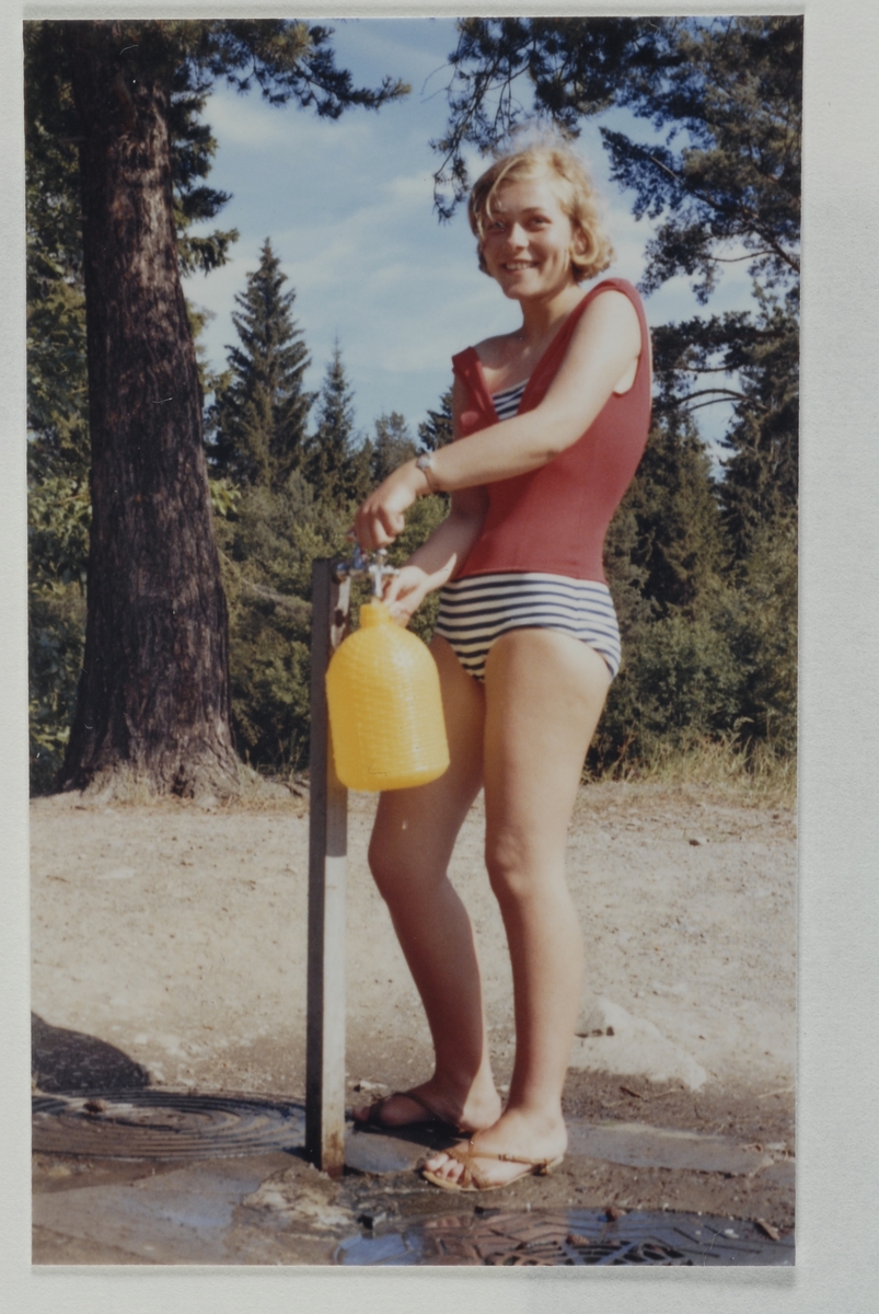 Hamar camping. Ung kvinne henter vann i vannkran.