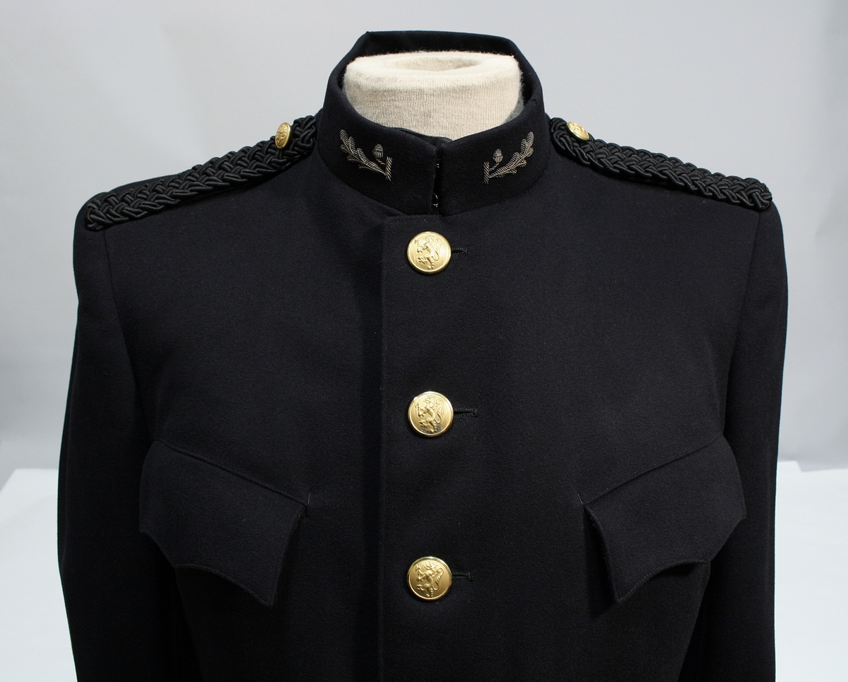 Sort jakke og bukse med blåskjær. Jakken er enkeltspent med seks forgylte knapper med riksløven. Stiv stående krage med broderte ekeløvblad, flettet sort skulderdistinksjon av sort innflettet gulltråd og en knapp. To brystlommer med klaff, ingen sidelommer. 

Kryssbandolær i brunt lær. Sort uniformslue med tresse og bratt skjerm i sort lakk og bredt luebånd med innvende eikeblader. Tressen er festet med to forgylte knapper. Gullforgylt luemerke.