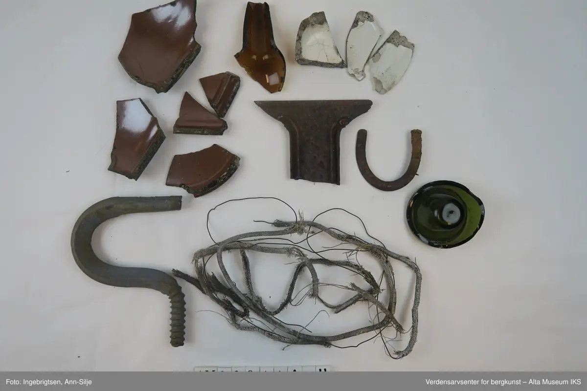 Tingene, med unntak av hestesko og krok, er ødelagte/fragmentert. Det er fragmenter av keramikk og porselen, to glassbiter fra flasker, en ledning med metallstrenger, stor krok og en liten hestesko.