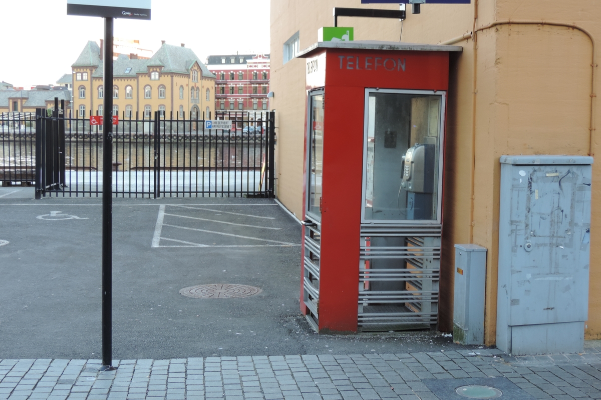 This is the story of how Norway’s most important conversation-space was designed by a young, freshly graduated man from Bergen.

“Norwegian architects are hereby invited…”
In the autumn of 1932, Oslo Telefonanlegginitiated an architectural competition. Finally, Oslo would get its own telephone booth. The city had had so called “talking-stations” from 1885, which in turn were overtaken by automatic telephones 
 only available at selected Narvesen kiosks. The state 
was of the opinion that now was the time to offer the public a better service; public telephone booths open 24/7, like the ones they already had in Sweden and England. But what would they look like, these new telephone booths? What considerations would it
 be necessary to take when designing it? The telegraph board developed a detailed list of demands and restraints: “The booth is intended to be placed outside on the streets and squares and need to be designed so that snow and ice does not hinder the opening and closing of the doors,” they wrote. “To prevent vandalism, theft, uncleanliness etc. inside the booth, it needs to be designed so that from all angles one may see what is going on in there.” Additionally, it would need to withstand storms and bad weather, and “preferably also being whipped by rain mixed with seawater” 

This was not all: The appearance would have to be «pleasing». The booth also needed to be movable, so that it could be taken in to be serviced at Telegrafverket’s main workshops. The reqired material was iron, and the surface was to be spray painted  preferably using car-body paint. There was a requirement for “a writing shelf, a pack shelf, and a suitable place for the telephone catalogue.” Also, there would need to be an illuminated TELEFON  sign, easily visible from all four angles. The total cost for each booth should not exceed 1000 kroner. The first prize for coming up with such a product was 800 kroner.

“Norwegianarchitects are hereby invited to partake in a competition for the design of a telephone booth…”  

The man with the solution
«At some point in 1932, Georg Fredrik sat at a party in Bergen. Maybe he felt a bit lost and forgotten as he often had throughout his life. He retreated to a quiet corner, took out a pencil and strted doodling on a matchbox.  According to my mother, this was how the telephone booth came into being.” In the book “Norges lille røde  historien om telefonkiosken,” Lars Fasting describes his father, the man who is far less known than the iconic architctural structure he left behind. Georg Fredrik Fasting was from Bergen, born into a family of working people and smallholders. One unusual facet of Georg Fredrik was that he was born without ears. His mother made sure he learnt to speak, read and write, 
ut Lars Fasting indicates that his father would seek refuge in drawing when the social challenges became too much to bear. And in the end drawing became his profession. In 1924 he secured a guarantor for a student loan, and started studying to become an a
rchitect at the NTH. Throughout the 1930s he entered several architectural competitions, with drafts produced, according to his son, “after work and in the late hours of the night.”

His efforts were not wasted. Out of 93 entries, with names such as “Flirt”, “Brrr”, “Ring” and “Amor”, the jury selected Fasting’s submission, “RIKS” as the new telephone booth: “The draft shows a strikingly simple solution to the task, technically as well as aesthetically well worked out.”

Taut and provident
Simple and aesthetc are the keywords here. Fasting had designed a booth pointing towards the future, and to modernism. Just how modern it was can be seen by comparing RIKS to the British telephone booth, also designed in the interwar-era. While the British version with it classicistic style is looking back to the heyday of the empire, Fasting’s booth is progressive and functionalistic. Like most Norwegian architects, Fasting broke with the classicistic style of architecture after the Stockholm-exhibition in 1930. “After it, almost all buildings erected in Norway until the German invasion in 1940, were in the functionalistic architectural style,” writes senior curator of architecture at the Norwegian National Museum, Ulf Grønvold, in the book, “Den lille røde”.“TheNorwegian booth is a piece of functionalistic architecture, an asymmetric composition with its roof slab overhanging the word TELEFON, in bold sans seraph lettering,”concludes Ulf Grønvold.

Fashionably red
And it was red. Fasting chose a colour which was part of the modern palette. “A bright red colour, but not as shiny as a signal red, the character of the colour places it among the fashionable colours within functionalism,” states paintings conservator and researcher in NIKU (Norwegian Institute for Cultural Heitage Research), Jon Brænne. In his opinion, Fasting went for visibility without making the booth stand out too much from its surroundings. The original colour was in use up to around 1950, when it changed to signal red. Towards the end of the 1970s the clour was again adjusted towards today’s orangey red.

The design, however, has not changed. RIKS is eighty years and still looks remarkably good. That’s what makes Fasting’s telephone booth a classic  even before it was added to DOCOMOMO’s list over moden icons of design. For Telenor, the telephone booth has served as a pathway into the hearts of the public. For many, Telenor (Televerket) was synonymous with exactly this telephone booth, because this was where one would go to place a call. Having a home
phone was not common until the 1980s. As such the red box became part of the Norwegian everyday and consciousness. The symbol- and publicity value of this is hard to evaluate, but in 2007 it was time to give honour where honour was due, Telenor, in consul
tation with the Directorate for Cultural Heritage, decided to preserve 100 telephone booths for all eternity.

And what about Georg Fredrik Fasting? What happened to him? At the age of 56 an entry in his diary states: «I CAN HEAR». As the first person in th world he had undergone an operation where he had ear canals constructed and eardrums fitted. For the rest of his life, the man behind Norway’s own telephone booth could answer the telephone himself.

Source: Norges lille røde historien om telefonkiosken (2007), issued by The Norwegian Telecom Museum and Telenor Cultural Heritage.