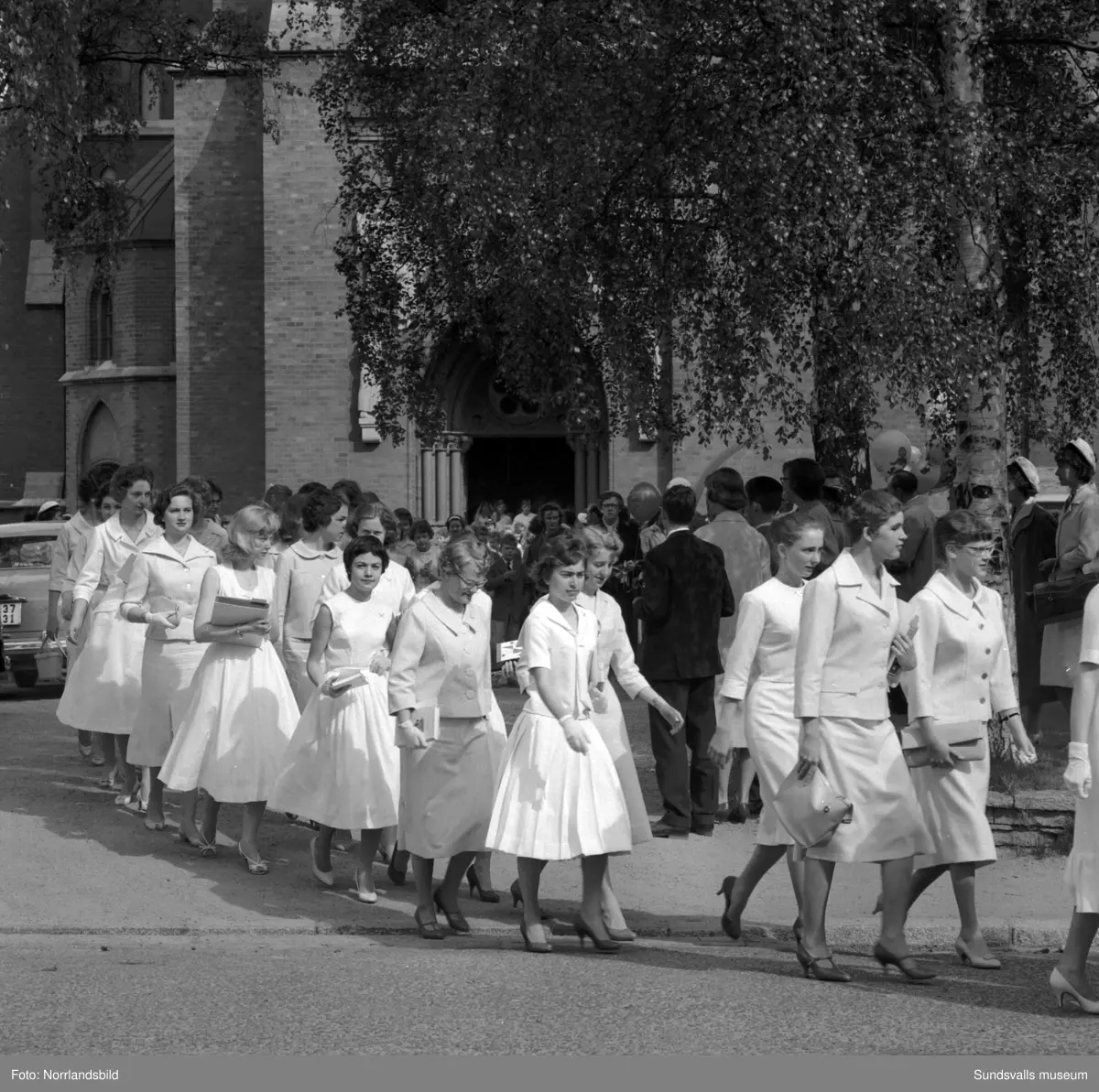 Examen för flickskolan, uttåg från kyrkan, gruppfoto och gratulationer.
