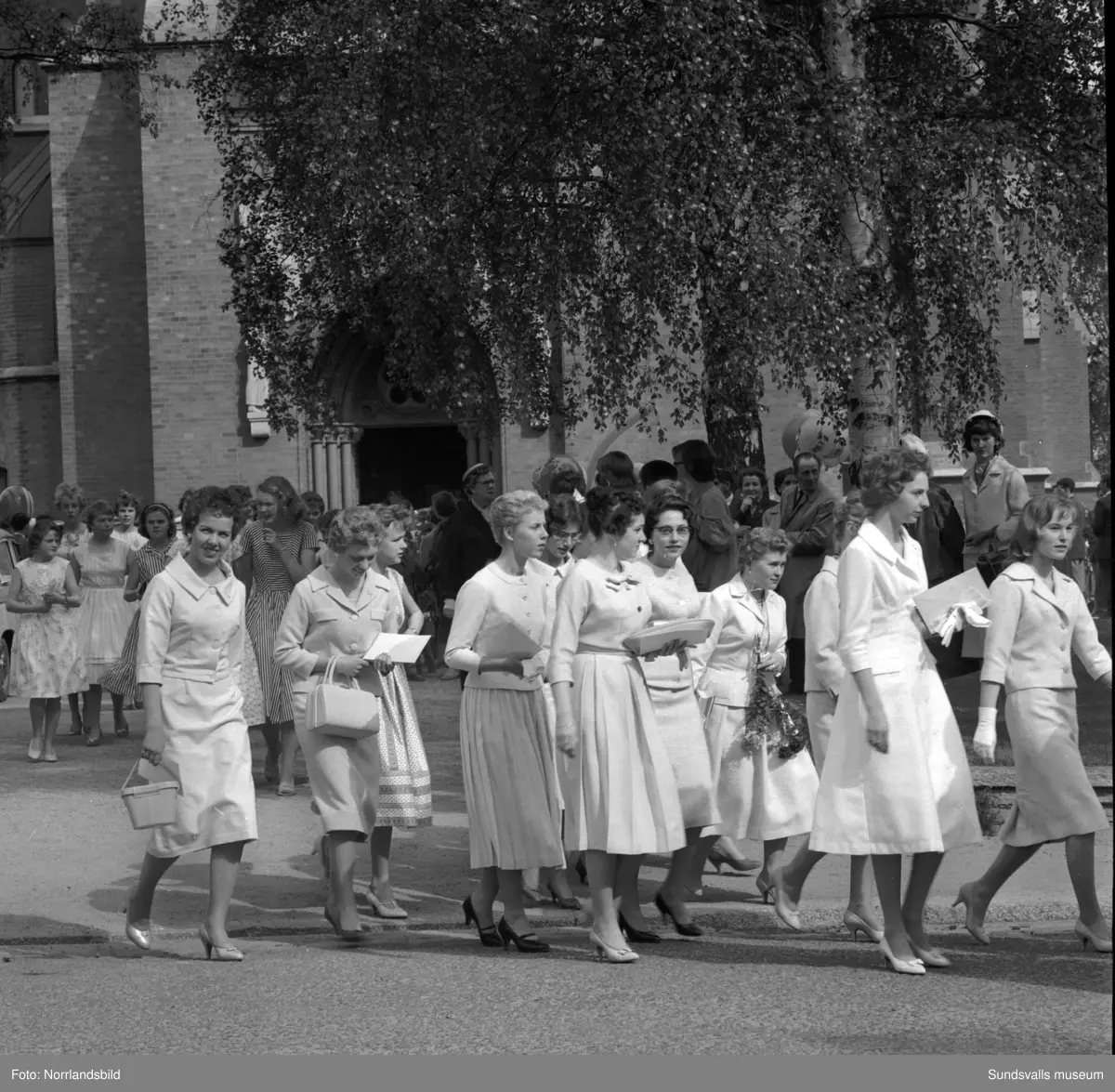 Examen för flickskolan, uttåg från kyrkan, gruppfoto och gratulationer.