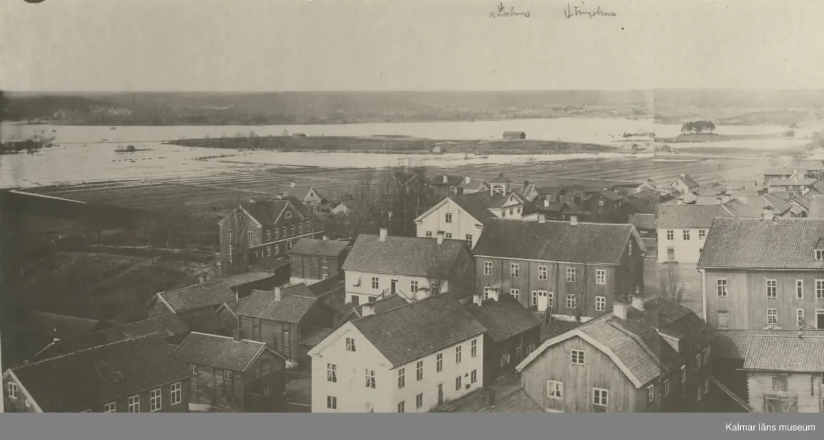 Vy över Vimmerby. Detta är ett foto på den gamla bebyggelsen kring torget och Storgatan i Vimmerby. Fotot är taget ifrån kyrktornet. Två-våningshuset med brutet tak som man ser till höger är där Handelsbanken ligger idag. I bildens nerkant skymtar man även taket på Rektorsgården där stadsbiblioteket låg på 50-60-talet. Det stora huset man ser bakom rådhuset är där stadshuset ligger idag.