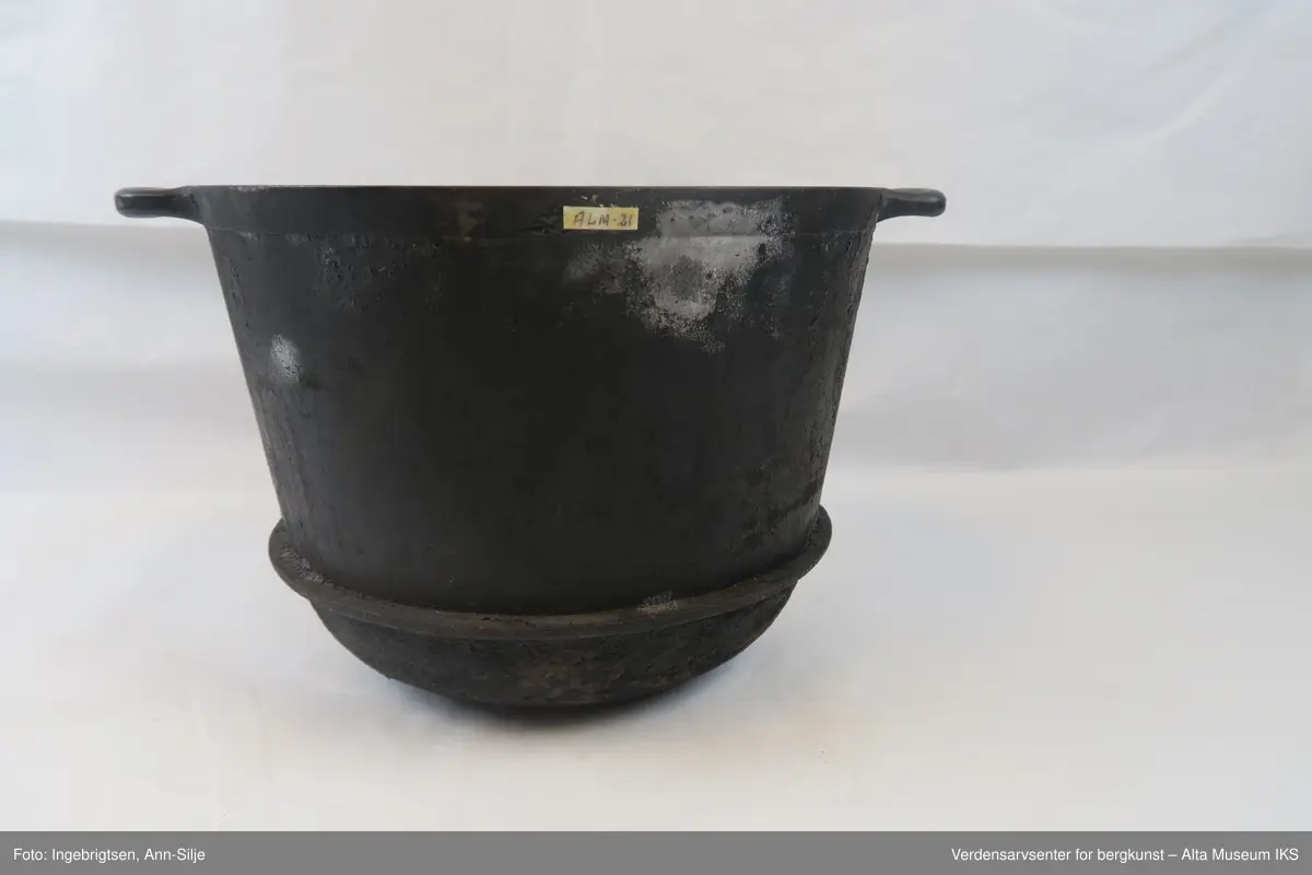 Form: Gryte, som har en 1 cm tykk kant 5 cm over bunnen. To håndtak ved toppen.
