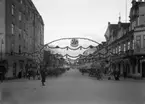 Juldekoration över Järnvägsgatan 1928. Fotografen/kopisten har lagt till en krans med bokstäver mitt i bilden.