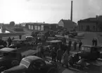 Motormännens bilkortege vid Inre Hamn med ångkraftcentral tillhörande Karlstads elverk i bakgrunden och tullhuset till höger. 1948 avvecklades ångcentralen då en ny togs i bruk vid Lambergskanalen i Yttre hamn . Bilden togs 1936.