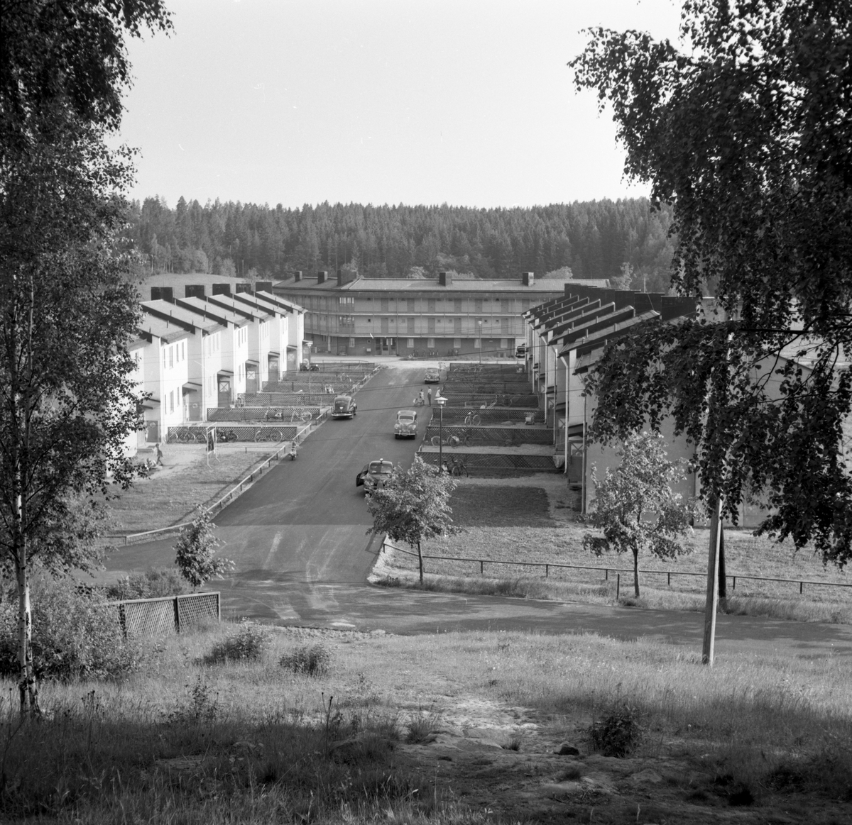 Någonstans i Värmland - från slutet av 1950-talet. 
Kommentar från en användare: Älvenäs, gatan rakt fram är Spinnaregatan, och längst ner ligger ungkarlshotellet. Alla husen är rivna men gatan finns kvar! Jag bodde i det vänstra huset 1966. Bakom granskogen går i dag E18 fram.
Ungkarlshotellet kallades också i folkmun för "Sing Sing"p.g.a sin utformning.