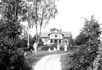 Grupp framför villa på en bild från 1906.