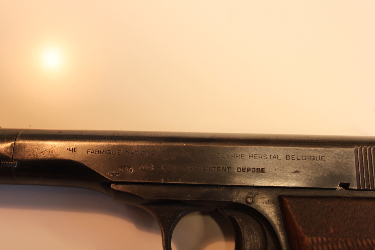 Brunt deksel på hver side av pistolskaftet. Med «Rutemønster». Festet med gjennomgående skrue. Magasin sitter i.