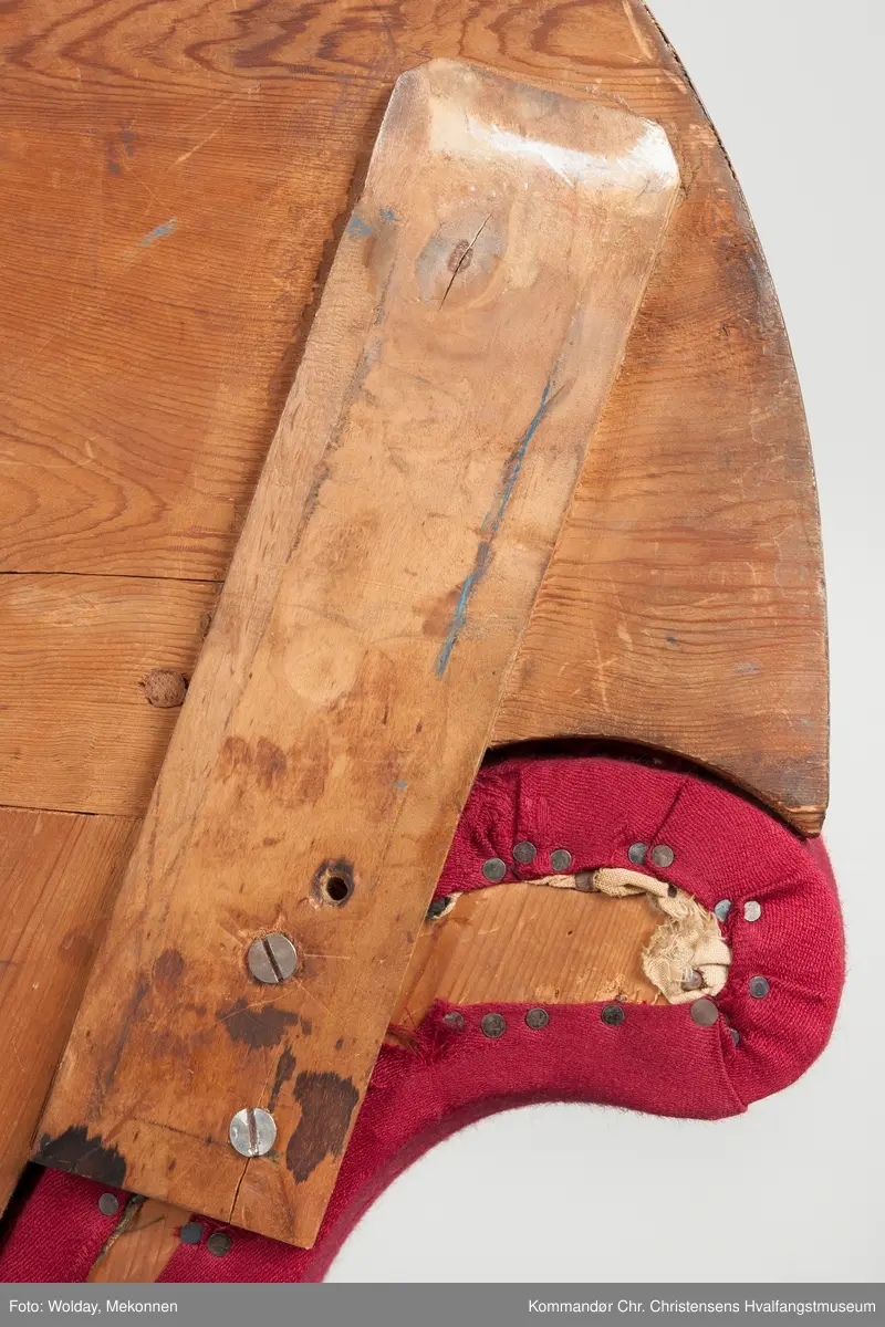 Akantusdekor i treverket. Dekor m/possementsnorer. Baksiden av sofaen er laget av et billigere treslag, der det ikke synes. Sofaen er nok ment å stå inntil en vegg. Grønt stoff ble brukt som underlag før det røde.