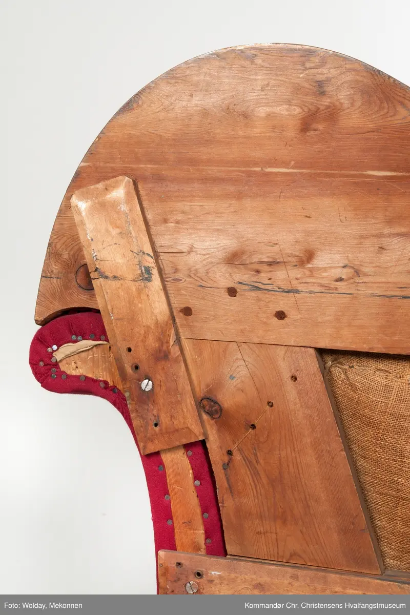 Akantusdekor i treverket. Dekor m/possementsnorer. Baksiden av sofaen er laget av et billigere treslag, der det ikke synes. Sofaen er nok ment å stå inntil en vegg. Grønt stoff ble brukt som underlag før det røde.