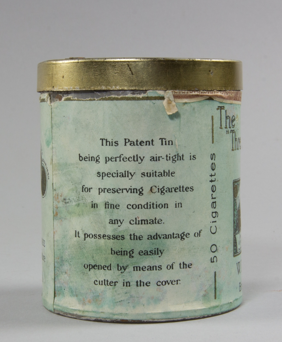 Burk, cylindrisk, av plåt med plant avtagbart lock. Präglad text på locket. Runt burken påklistrad pappersetikett. Burkens insida pappfodrad. Burken innehåller fem cigaretter.
