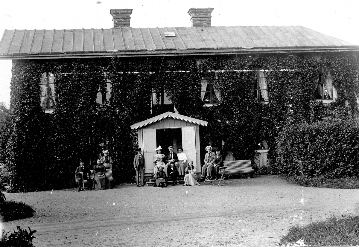 Sex kvinnor och sex män framför ett bostadshus. Fotograf Alfred Bergendahl. Givare H Bergendahl.