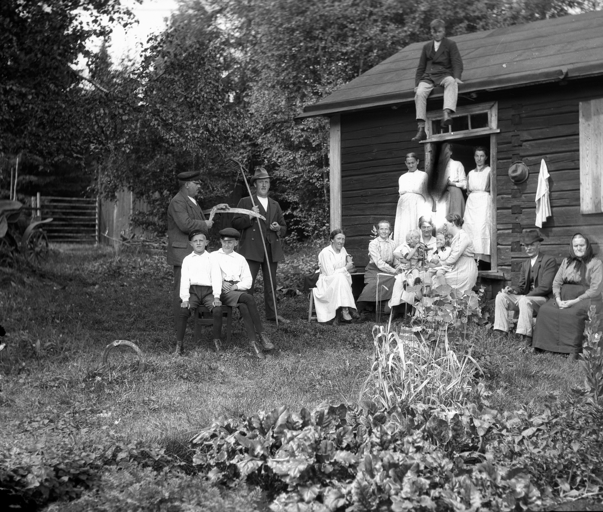 Släkten samlad en sommarsöndag vid Åsmundshyttan nr. 9 "Erik-Anders" fäbodstuga. Det är Anna Hansson som bjudit sina syskon Lotten och Axel med familjer och sina systrar Maria och Olga. 
På taket Joel Hansson f. 22 augusti 1903, d. 17 november 1975. Bakre raden från vänster Per Jönsson f. 2 december 1870, d. 8 juni 1935, Axel Jönsson f. 23 mars 1883, d. 7 september 1963, Bengt Jönsson f. 6 mars 1919, d. 25 juni 1973, Lydia Jönsson f. 21 februari 1891, d. 13 juni 1976, Anna Greta Westlund, Maria Jönsson f. 5 mars 1888, d. 20 januari 1980, Anna Lind f. 3 juni 1890. Främre raden från vänster Valle Jönsson f. 30 oktober 1913, Anselm Jönsson f. 18 augusti 1910, Olga Jönsson f. 24 januari 1891, d. 24 maj 1927, Anna Hansson f. 9 april 1876, d. 3 december 1949, Greta Jönsson f. 13 september 1919, Lotten Jönsson f. 6 januari 1881, d. 3 januari 1963, Per Hansson f. 5 januari 1864, d. 14 november 1929 och Brita Andersdotter.