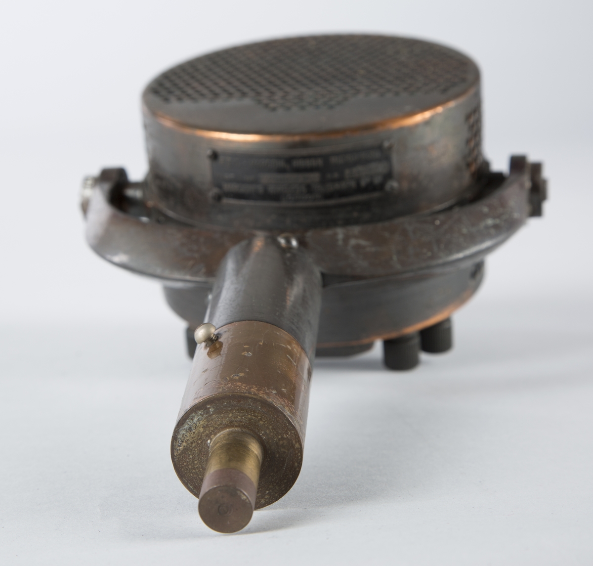 Mikrofonhode som er festet på et kort stativ. Mikrofonen kan rotere i to plan (stativ rundt egen aksel og hode i vannrett plan). Mikrofonskall av kobber perforert med mønster med runde hull som lager et nett. Stativ av kobber og stål(?). Fotplate mangler.
Tre kontakter for ledning.