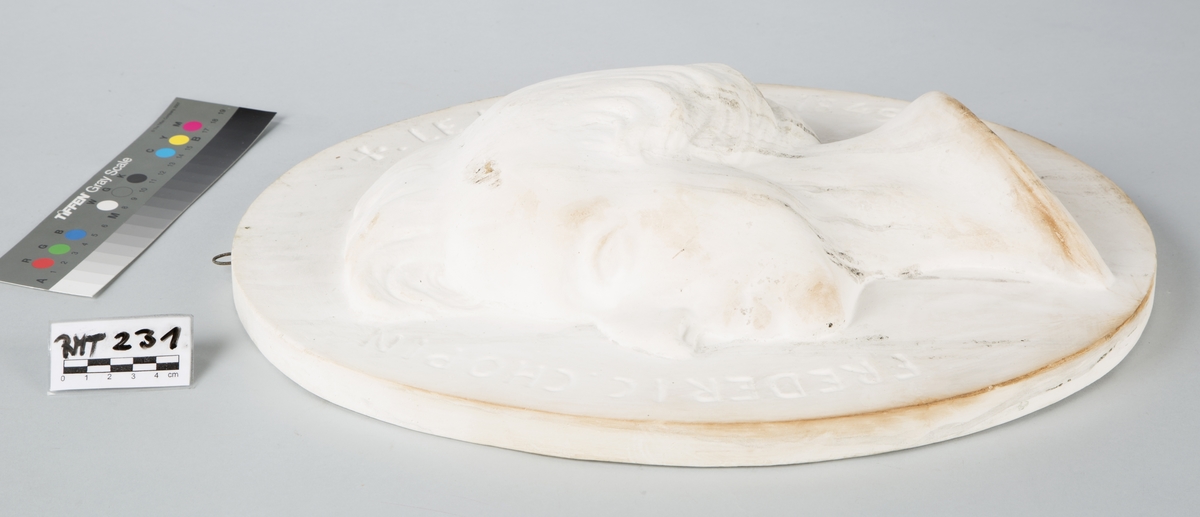 Oval plate. Relieff av F. Chopins hode i profil (venstre). Hvit gipsavstøpning.