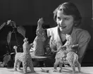 Formgivare Dorothy Gunnarsson (Clough) med keramikfigurer och en klockmalva.