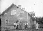 Framför huset. Tidsomfånget är 1900 - 1940