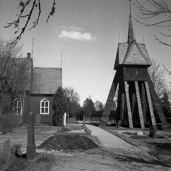 En träkyrka med klockstapel till höger. 
Tutaryd.