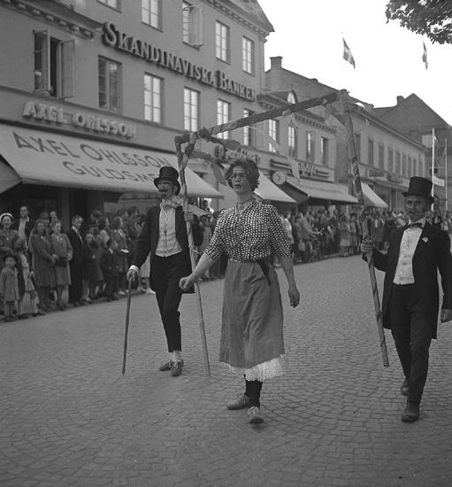 Barnens Dag, 31/5 1946.
Några utklädda herrar eskorterar en utklädd "dam" längs Kungsgatan.