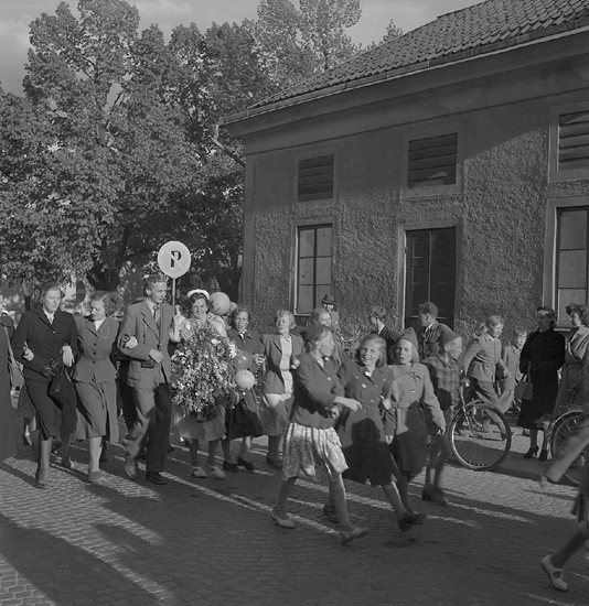 Studenterna andra dagen, 1950.
Studenter och anhöriga m.fl. på väg utmed Storgatan mot Stortorget, strax efter korsningen Linnégatan.

Angående avgångsklasserna 1950 - se "Lärare och Studenter vid Växjö 
Högre Allmänna Läroverk 1850-1950" (1951), s. 193-196, 289.