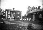 Gruppbild framför bostadshus, Karl Jonsson med boskap. Pojkarna okända, damerna från vänster: Beda Viberg, okänd, fröken Anna Blomberg (bodde i den lilla stugan) och fröken Mina Jonsson, syster till Karl, hade affär på Vifors. Foto tidigt 1900-tal.