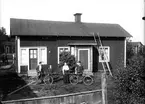 Familj framför bostadshus, okänd plats.