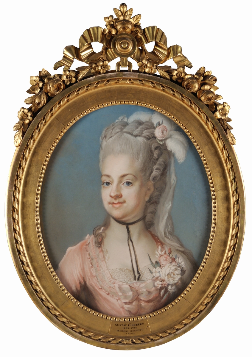 Porträtt, pastell, av grevinnan Juliana Duvall (1759-1789), gift med greve Fredrik Adolf Ulrik Cronstedt. Målat av Gustaf Lundberg. Bröstbild face vänster. Rosa klänning med blommor i dekolletaget. Blå bakgrund.
Montering/Ram: Originalram med originalförgyllning. Överstycke av rosett och blomstergirland. Pendang till G.M. 15707.