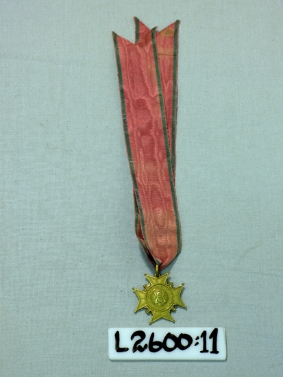 Ett 35 mm brett ripsband (grönt-rosa-grönt) med vidhängande 
malteserkors (metall). 
På ena sidan präglad text: "Memoria Dulcis", på den andra: "D 6 Januarii 1653, D 24 Julii 1760"
Trol. Amaranterorden. 

Inskrivet i huvudboken 1933.
Funktion: Ordenstecken för Amaranterorden