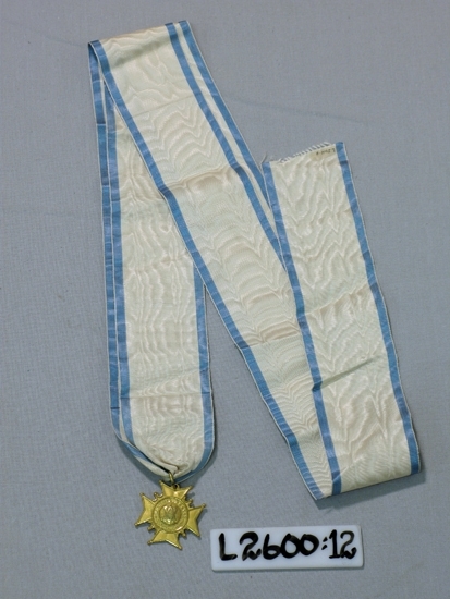 Ett 55 mm brett ripsband (blå-vit-blå) med vidhängande malteserkors 
(metall). På ena sidan text: "Memoria Dulcis", på den andra: "D. 6 Januarii 
1653, D 24Julii 1760".
Trol. Amaranterorden.

Inskrivet i huvudboken 1933
Funktion: Ordenstecken inom Amaranterorden