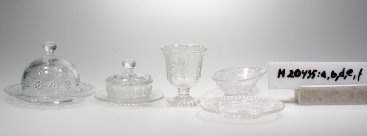 Glasskål, till dockservis.
Oval.
Pressglas.
Dekor: Blommönster.