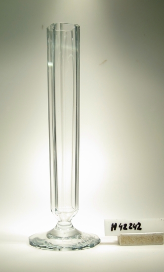 Vas.
Åttkantig hög slipad kupa, trattformad. Slipad 12 kantig fot.
Kapad (sågad).
Klarglas.
Grav:"B 422"

Gåva av Orrefors glasbruk AB 1980.
Funktion: Vas