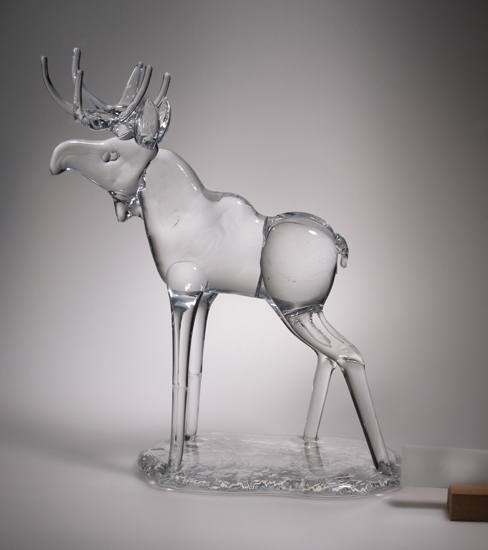 Prydnadsskulptur, i form av en älg.
Hyttarbetat, d.v.s. skulpterat på frihand.
Djuret står på en sockel av glas.

Gåva av konstnären och glasblåsaren Nils Nilsson i samband med utdelningen av Hald & Gatestipendium i dec 1986.
Funktion: Prydnad