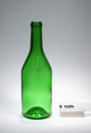 Vinflaska. Tillverkad på PLM Hammars glasbruk 1984-04-15. Kod nr. 8107-074. Ritning nr. Gl-9887. 
Ritning förvaras i arkivet.
Färg: Grönt klarglas.
Märkning: Relief runt nedre delen. Se "Signering, märkning" 1 ovan.
Relief i botten. Se "Signering, märkning"  2 ovan.
Inskrivet i huvudkatalogen efter 1990.
Funktion: Vinflaska