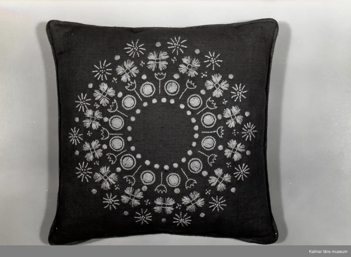 Broderad kudde med blomstermotiv från Birgittas Handarbetsaffär, som låg på Södra Långgatan.